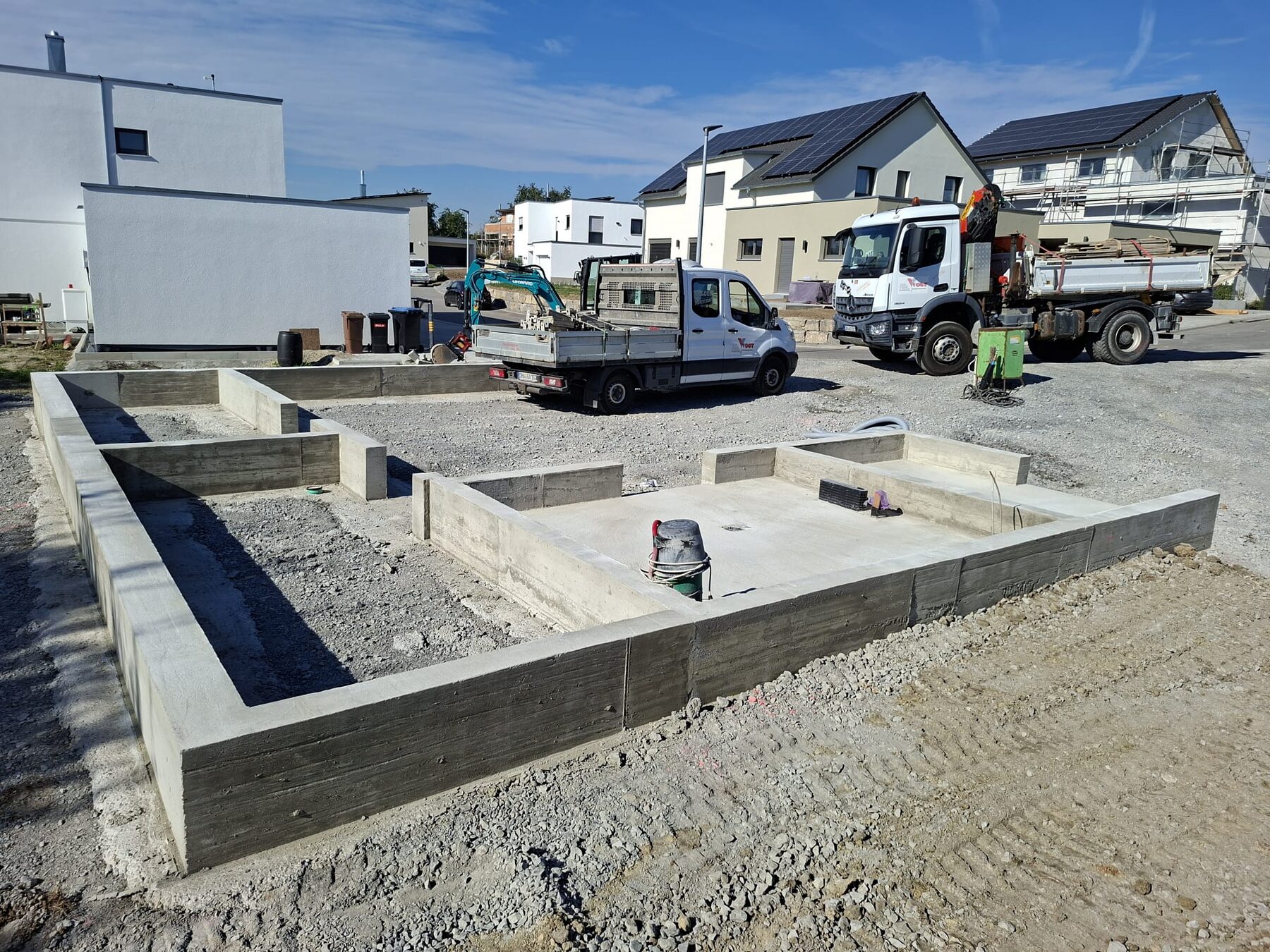 Gesamtansicht der Fundamentarbeiten in Obersontheim mit Firmenfahrzeugen von Vogt Bauunternehmen